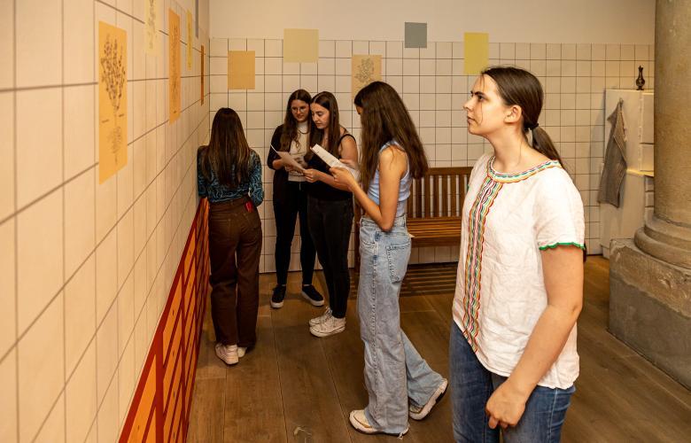 Jugendliche lesen Zettel an der Wand ab