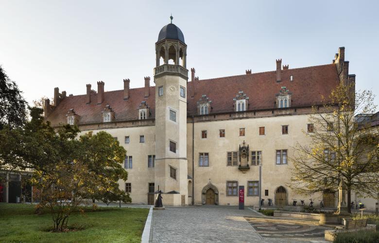Lutherhaus, links ein Baum, im Vordergrund der gepflasterte Weg