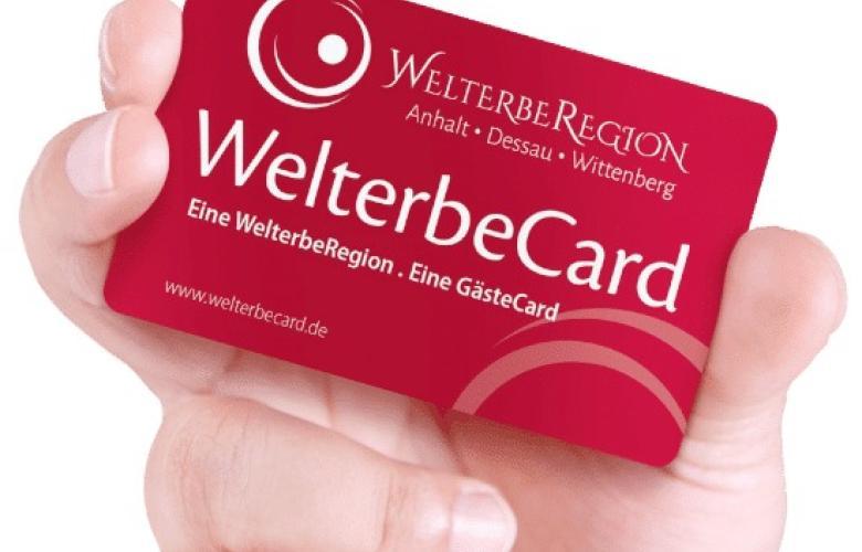 weißer Hintergrund, Hand hält rote Karte. weiße Schrift WelterbeCard