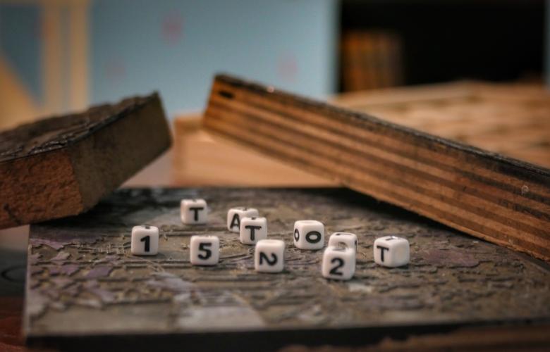 kleine Buchstabenürfel liegen auf einer Platte und ergeben "Tatort 1522"