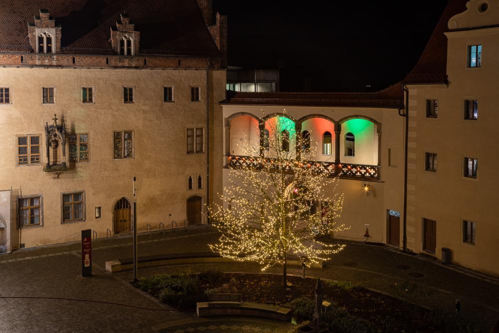 Lutherhaus im Hintergrund, beleuchteter Baum, bunte Fenster