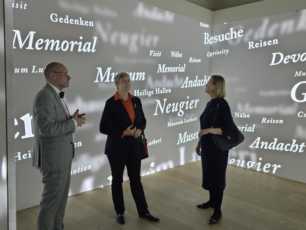 3 Menschen vor Digitaler Wand, dunkel