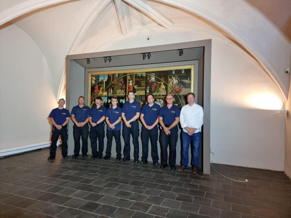 10-Gebote-Tafel mit 8 Männern davor