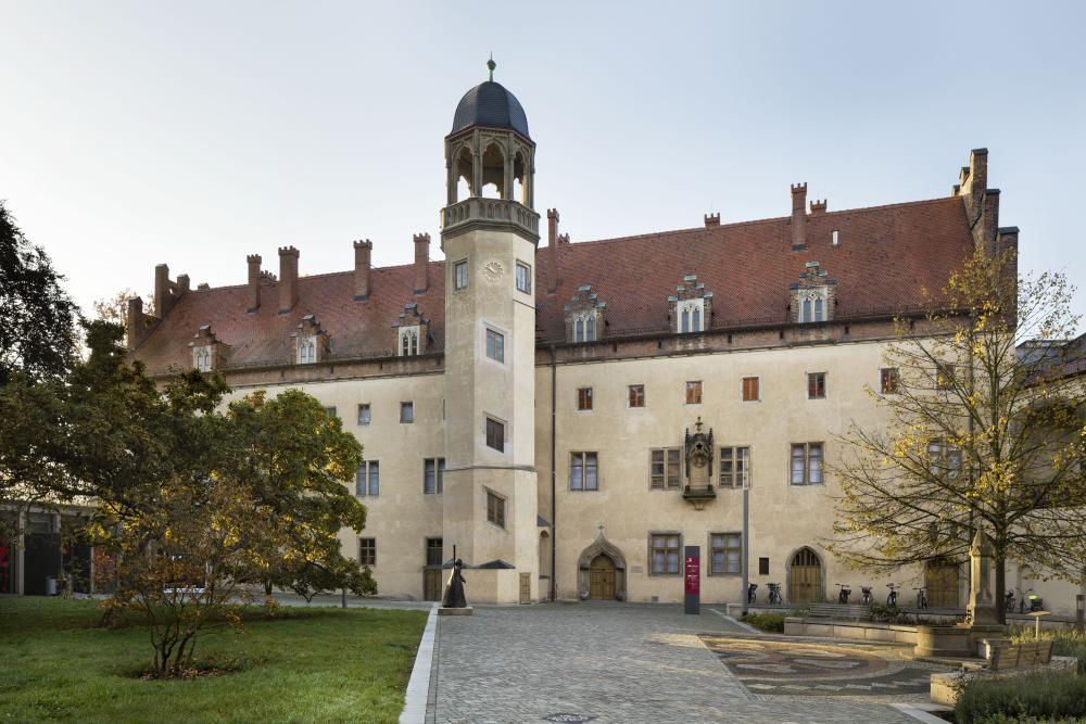 Lutherhaus, links ein Baum, im Vordergrund der gepflasterte Weg